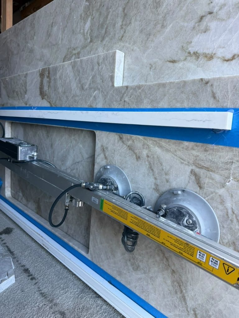 Vacuum lifter positioning a quartzite countertop with a mitered edge