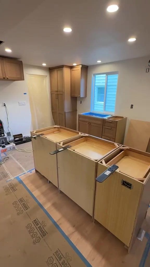New Taj kitchen before stone: island base cabinets set and leveled, no countertops yet
