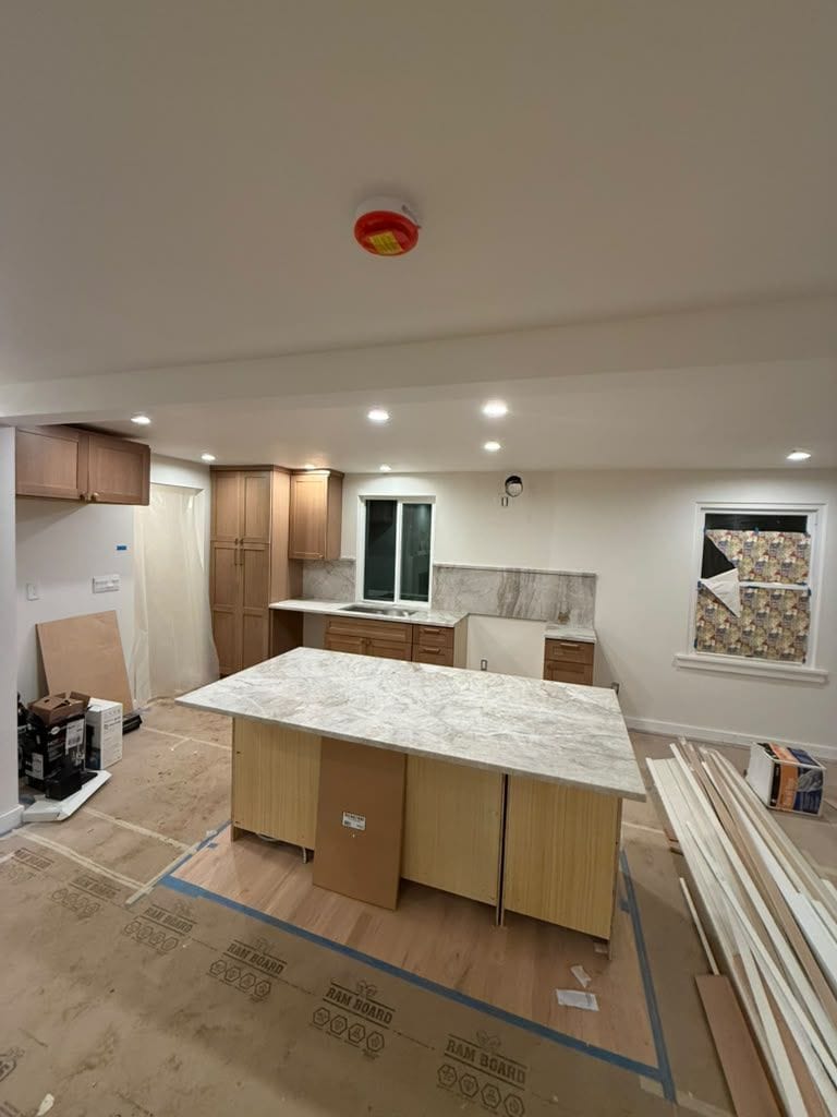 New Taj quartzite island and full-height backsplash during installation