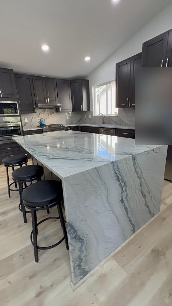 Quartzite waterfall island with bookmatched blue-grey veining