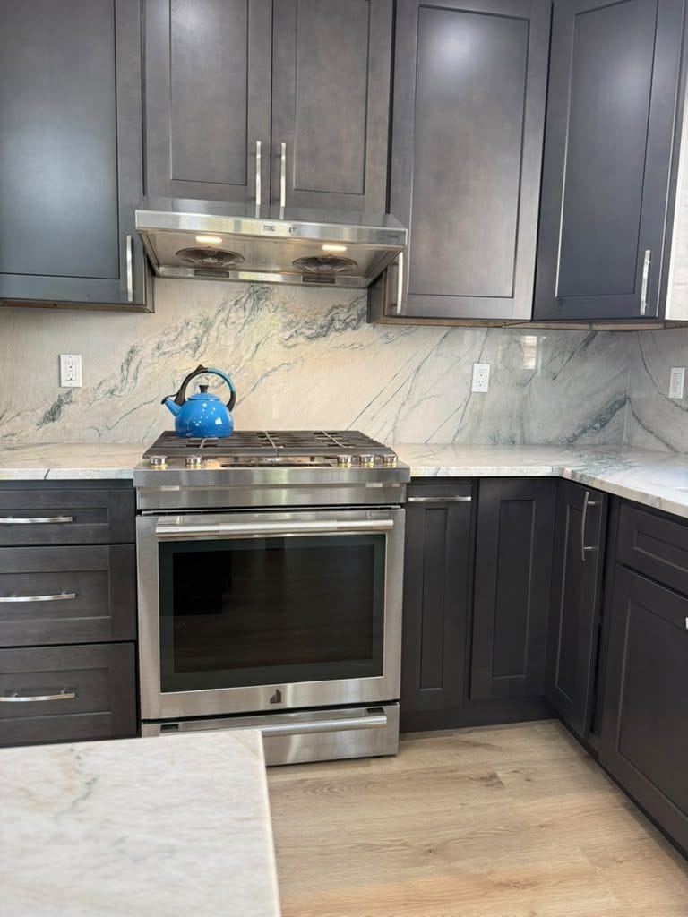 Close-up of veined quartzite backsplash behind the range
